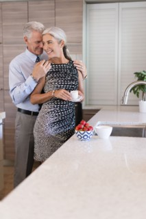 Caucasian couple hugging in kitchen