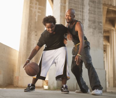 African father playing basketball with son