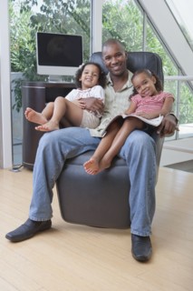 African American father holding daughters on his lap