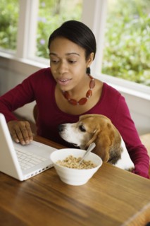 African woman with dog looking at laptop