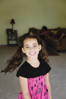 Grinning mixed race girl in living room