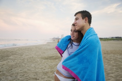 Caucasian couple hugging on beach