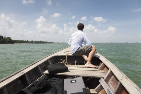 Caucasian businessman riding in boat