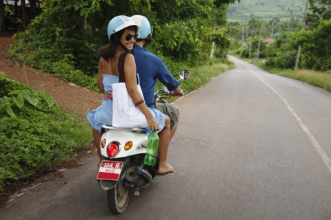 Couple riding scooter in remote area