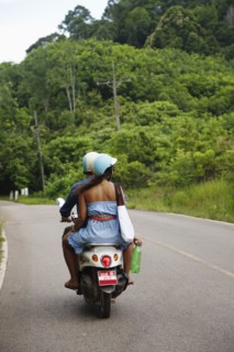 Couple riding scooter in remote area