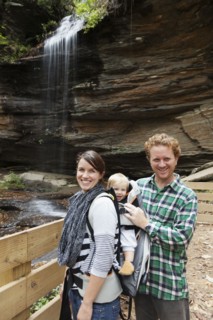 Caucasian family smiling by waterfall