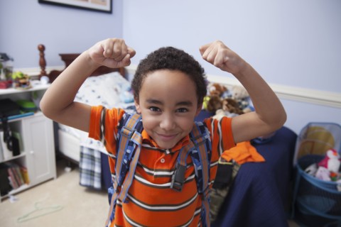 Mixed race boy wearing backpack in bedroom