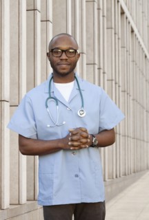Black doctor standing on city street