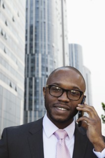Black businessman talking on cell phone on city street