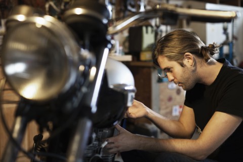 Caucasian mechanic working on motorcycle