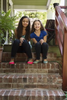 Mixed race sisters sitting on steps
