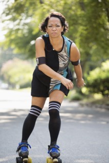 Mixed race woman roller skating outdoors