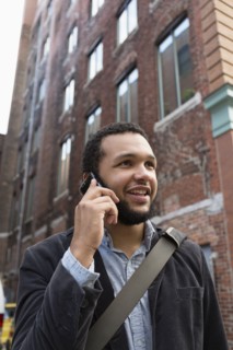 Mixed race businessman talking on cell phone in city