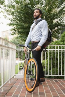 Mixed race businessman with bicycle on front stoop