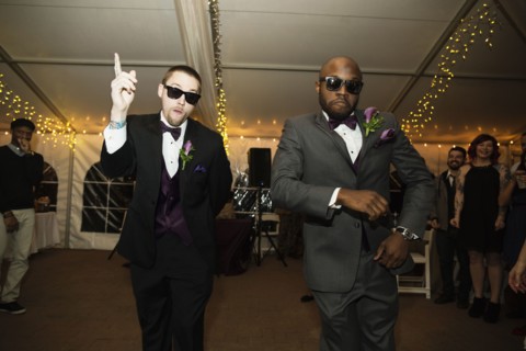 Groom and groomsman dancing at reception