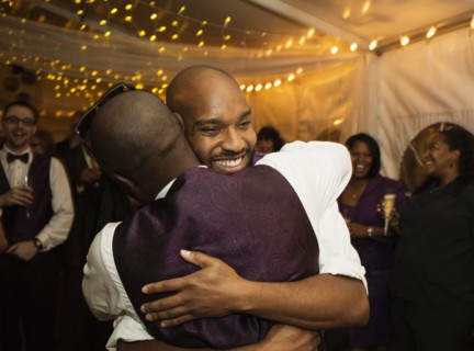Groom hugging groomsman at reception
