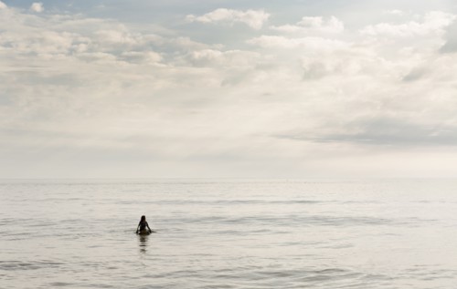 Hispanic surfer floating in water
