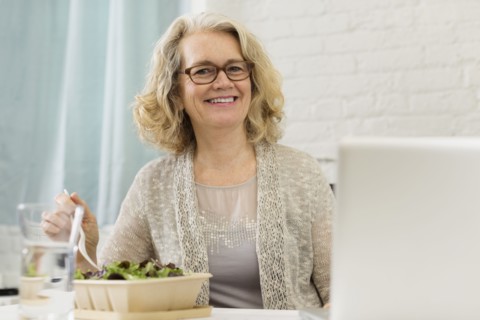 Senior Caucasian businesswoman eating salad