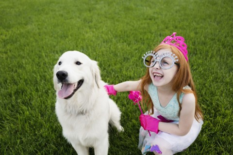 Caucasian girl playing dress up in park