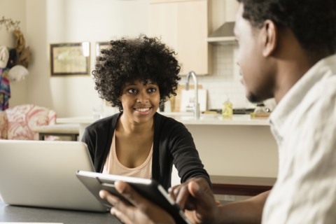Couple using technology at breakfast table
