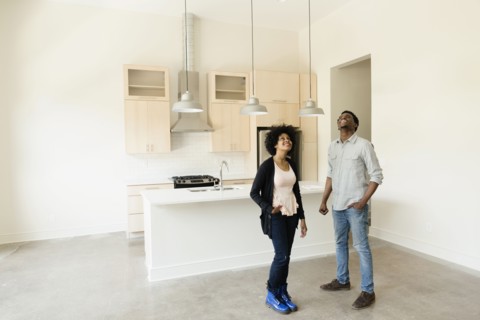 Couple standing in kitchen in new house