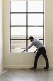 Mixed race realtor measuring window in new house