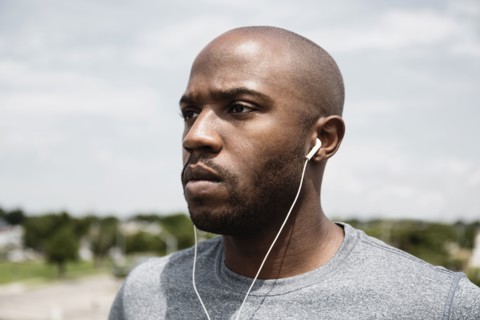 Black runner listening to earbuds
