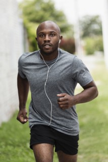 Black man running in urban grass