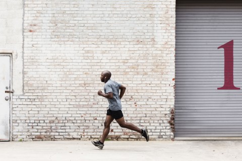 Black man running on city sidewalk