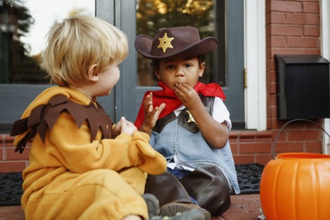 Boys in costumes eating Halloween candy