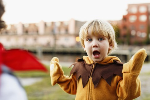 Caucasian boy playing in lion costume outdoors