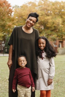 African American mother and children smiling in park