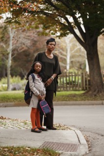 African American woman and daughter waiting for school bus