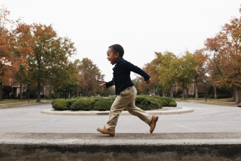 African American boy playing on suburban street