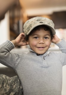 Mixed race boy wearing soldier cap
