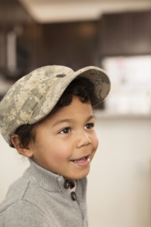 Mixed race boy wearing soldier cap
