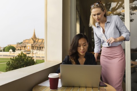 Businesswomen working on laptop in cafe