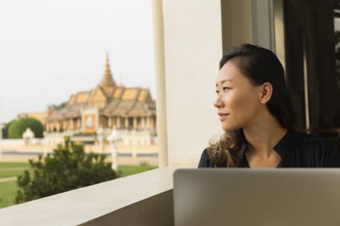Asian businesswoman admiring view from cafe window
