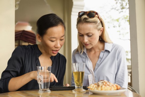 Businesswomen using digital tablet in cafe