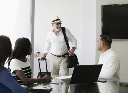 Businessman greeting colleagues in office meeting