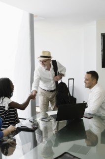 Businessman greeting colleagues in office meeting