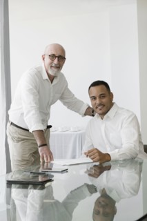 Hispanic businessmen smiling in office meeting