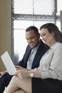 Business people using laptop in hotel lobby