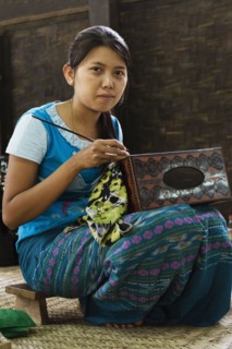 Asian artisan carving traditional design in workshop