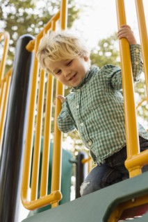 Caucasian boy on play structure in playground