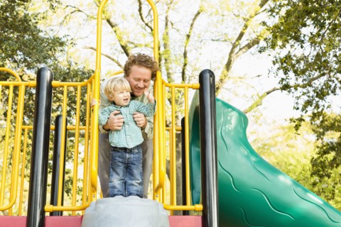 Caucasian father and son playing on play structure