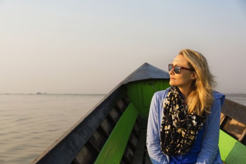 Caucasian woman riding in canoe on rural lake