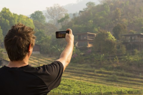 Caucasian man photographing rural fields