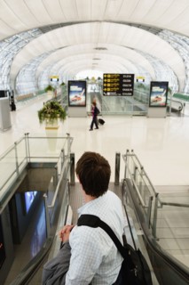 Caucasian businessman on escalator in airport
