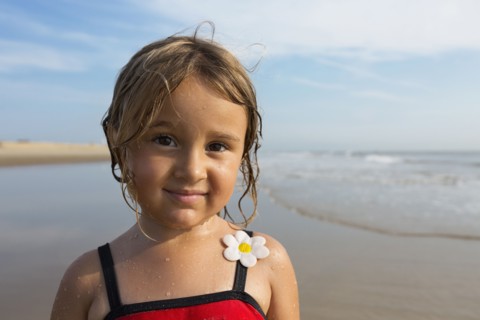 Mixed race girl smiling on beach